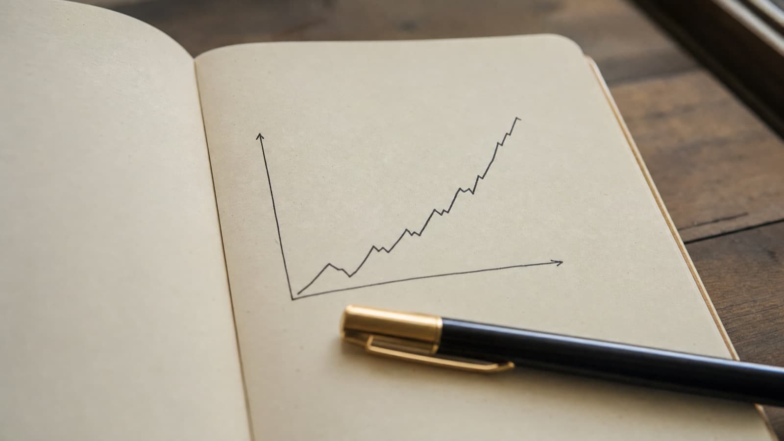 ノートに手描きの折れ線グラフとペン。婚活の数字を読み解くイメージ