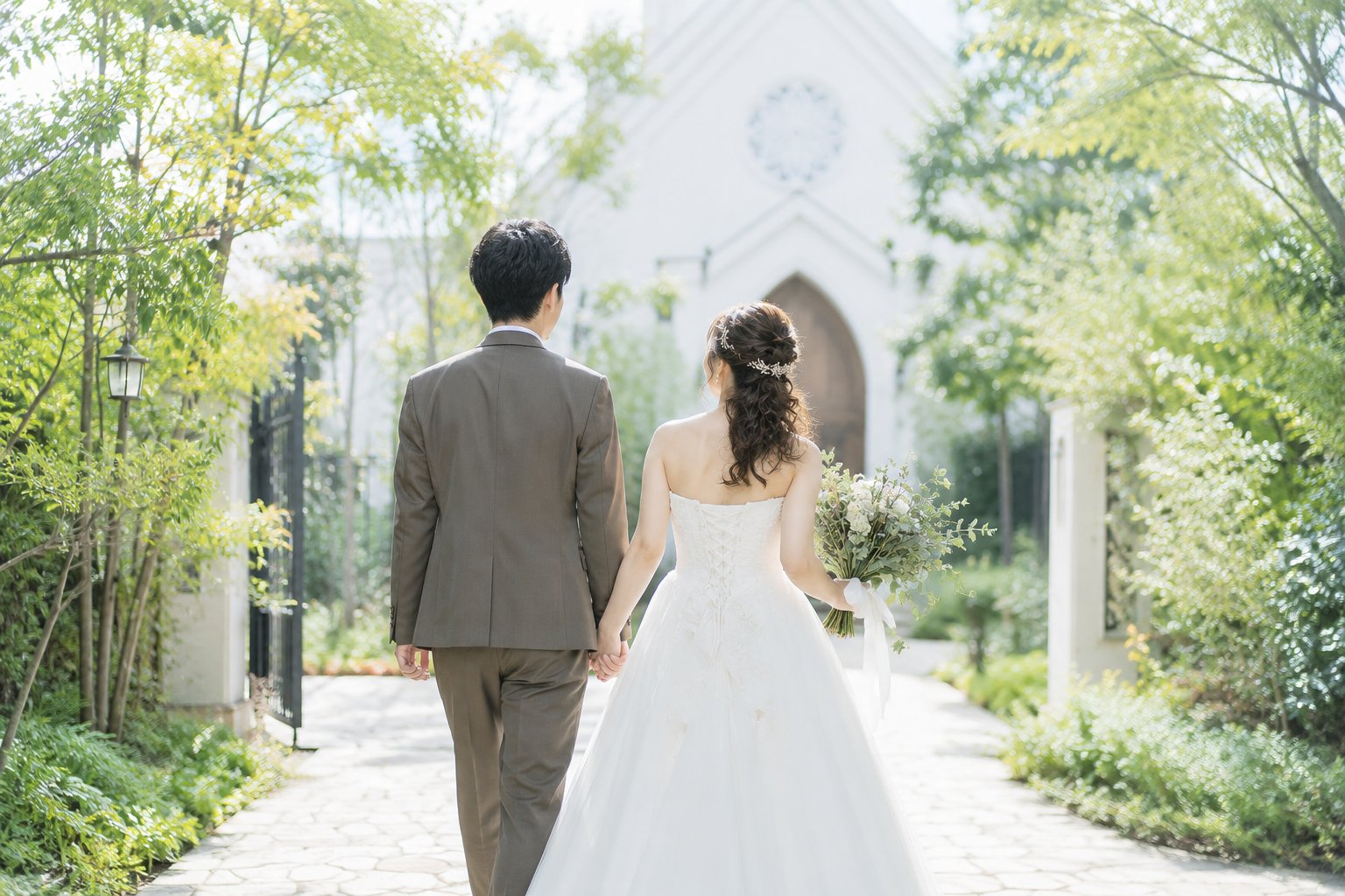 教会に向かって歩く新郎新婦の後ろ姿